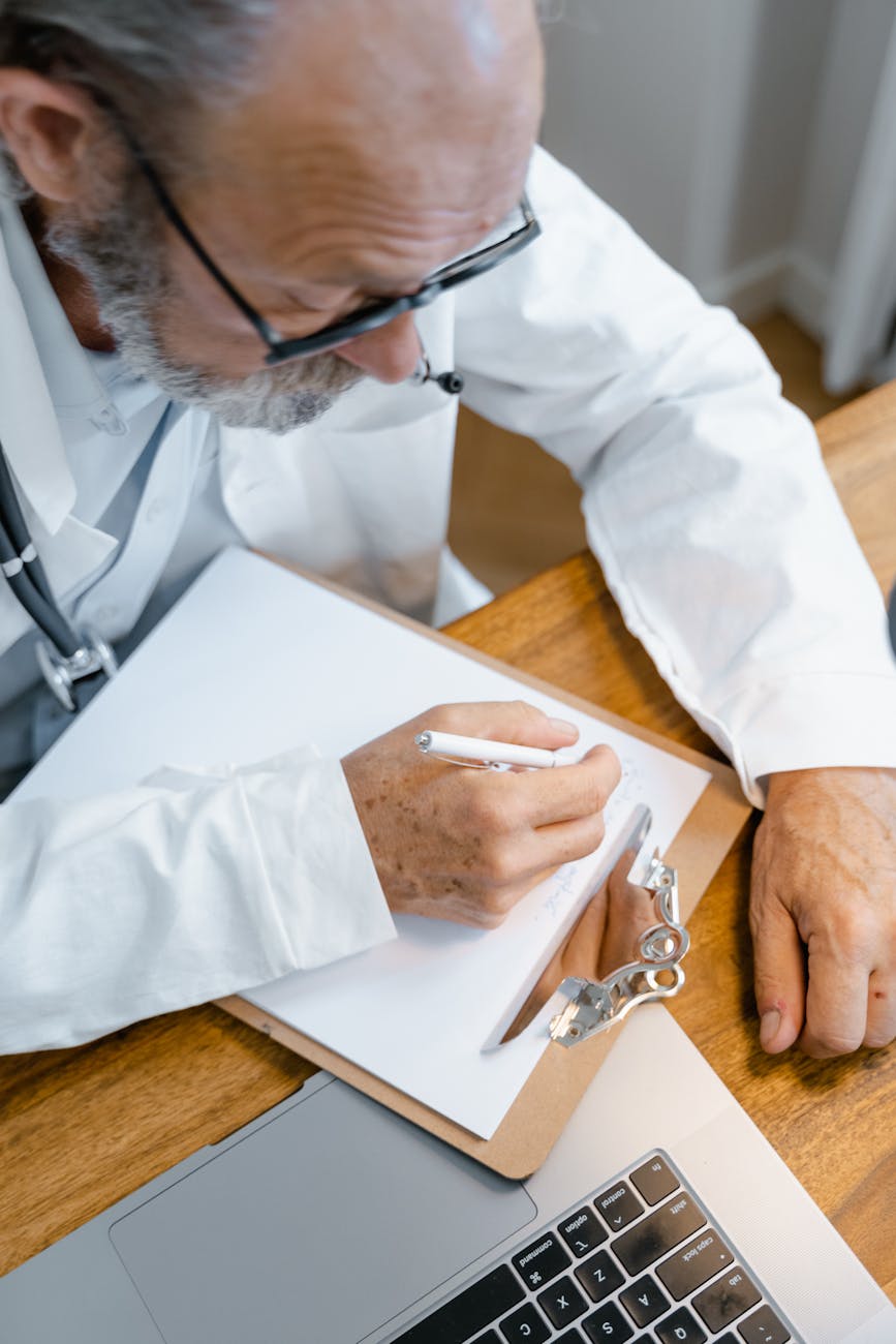 man in white long sleeves shirt writing on white paper